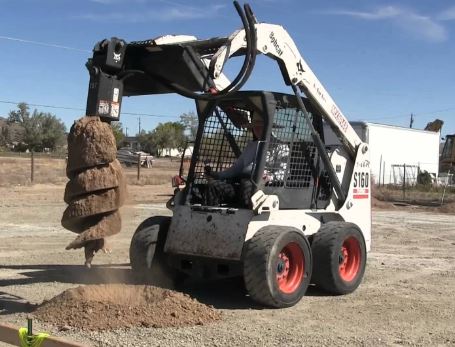 S160 Bobcat Skid steer with Post Hole Drilling or borer implement attached and being fed hydraulic power through Auxiliary circuit and Flat Face Manifold couplers  